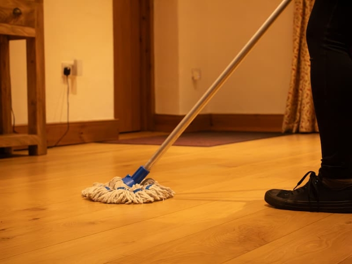 A dedicated cleaning operative meticulously cleans the floor in a house in Wymondham after post-construction work, ensuring a pristine and tidy living space.