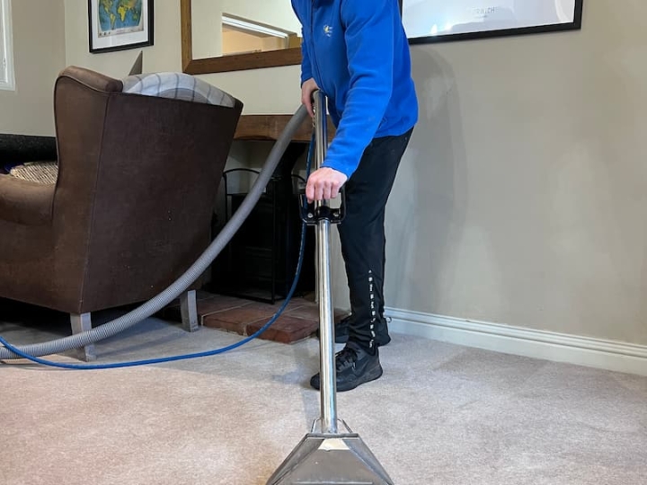 A cleaning operative using cutting-edge hot water extraction systems for professional carpet cleaning in a property in King's Lynn. The service is addressing dirty paw marks, targeting stubborn stains, bacteria, dirt, and allergens deeply embedded in the carpet pile, ensuring a thorough and effective cleaning process.