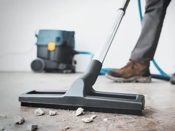 A skilled cleaning operative in Wymondham utilises a professional industrial vacuum to effectively remove debris and dust, delivering a thorough post-builders' clean and maintaining a pristine environment.
