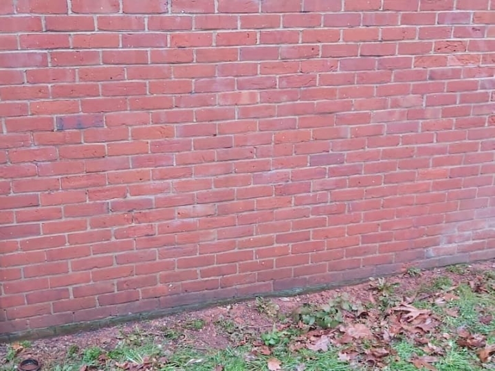 A red brick wall in Great Yarmouth, showcasing the success of a graffiti removal and restoration project. The wall, previously exposed to graffiti damage, now stands restored and free from defacement.